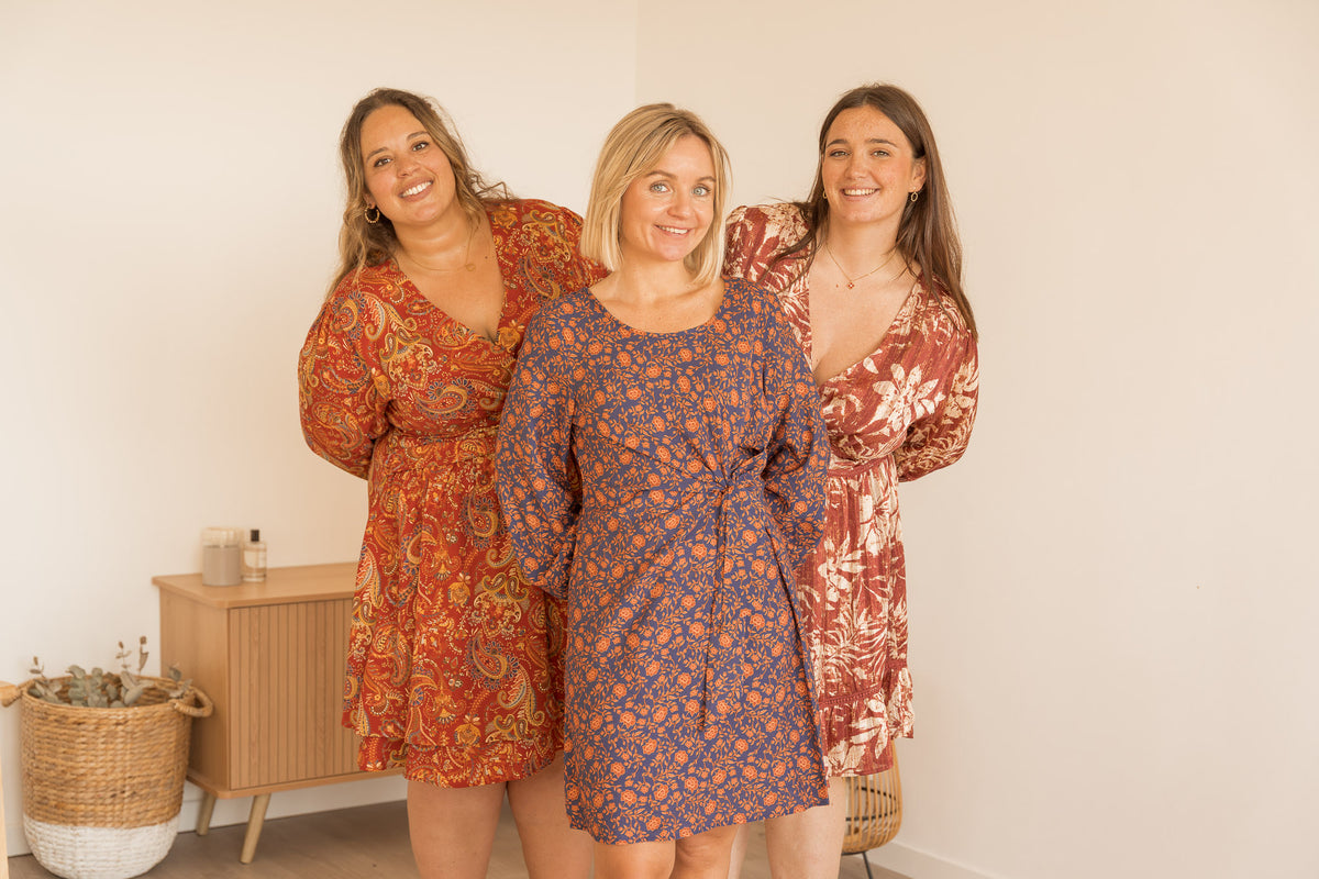 Les trois mannequins réunies, souriantes, en robes de la collection